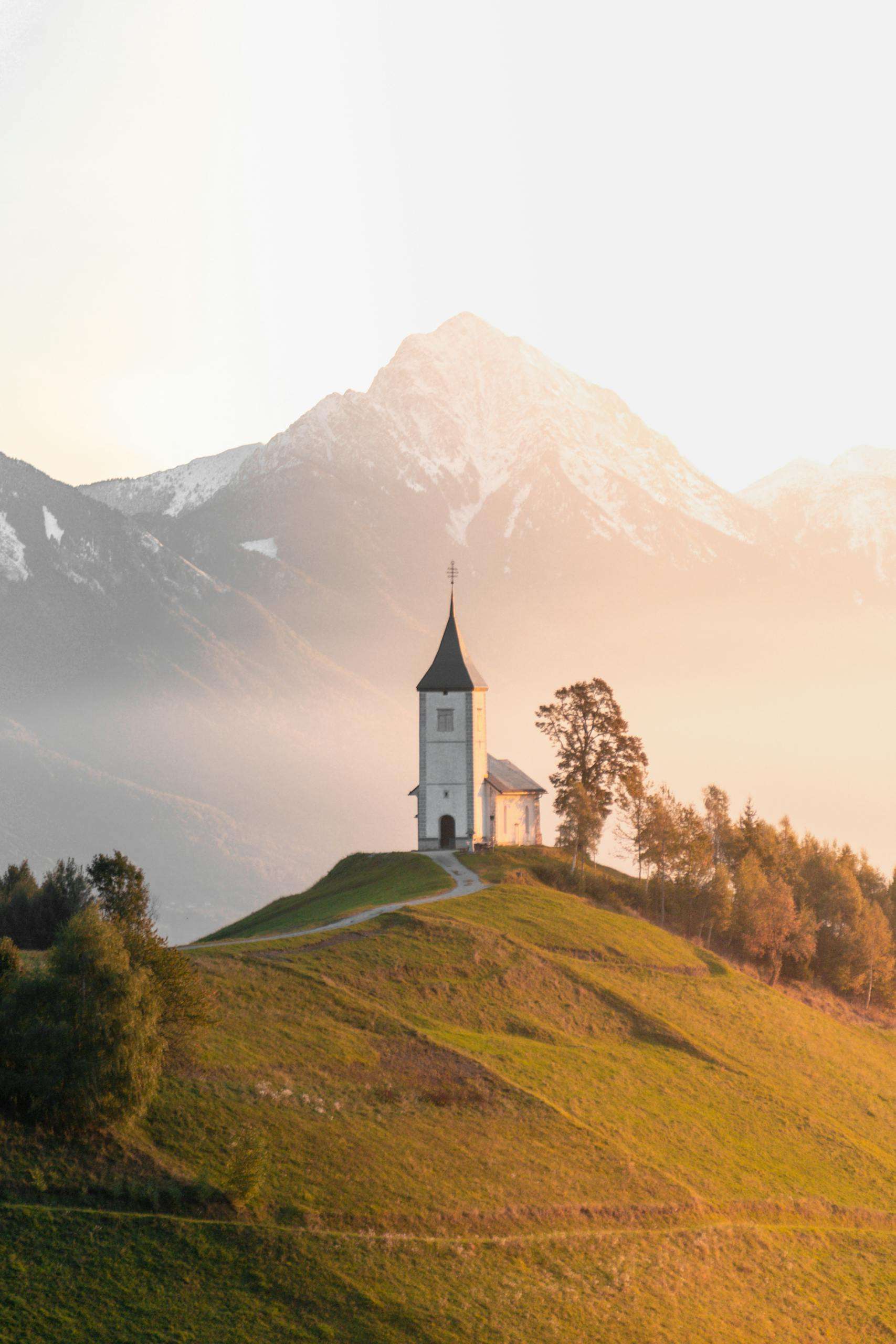 Home Breathtaking view of the Jamnik church against the backdrop of mountains during sunrise in Slovenia.